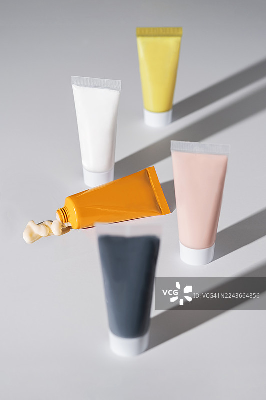 极简背景下的彩色化妆品软管和护肤霜图片素材