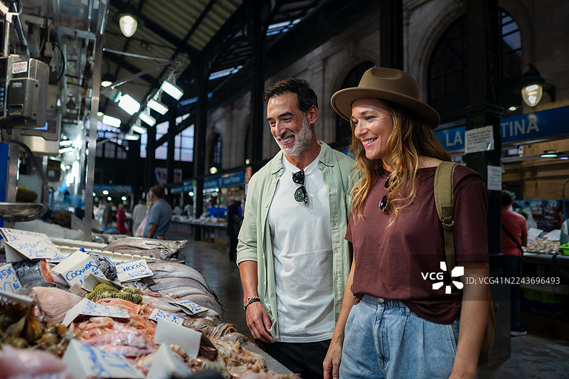 情侣在室内鱼市选购新鲜海鲜图片素材