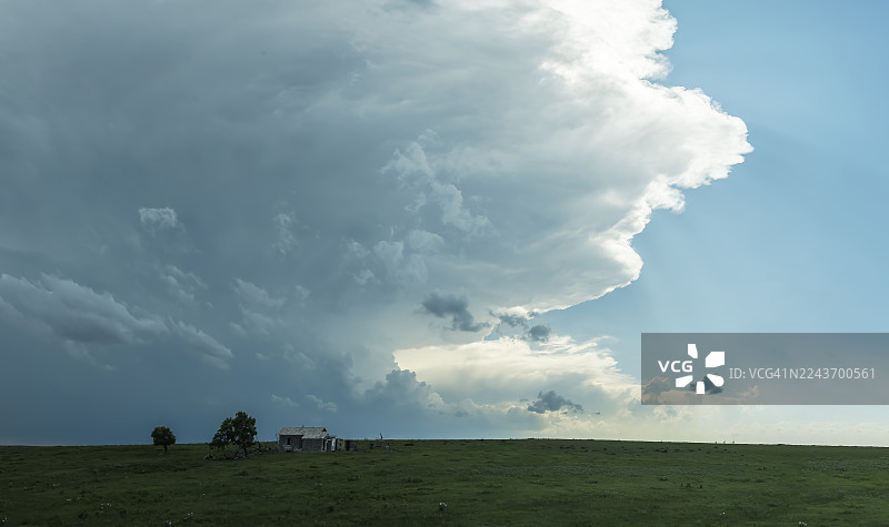 大平原上废弃的老建筑，上方是超级单体风暴图片素材