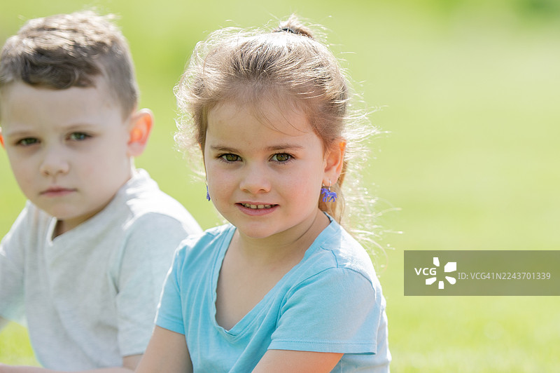 快乐的户外儿童肖像，绿野中女孩和男孩的合影图片素材