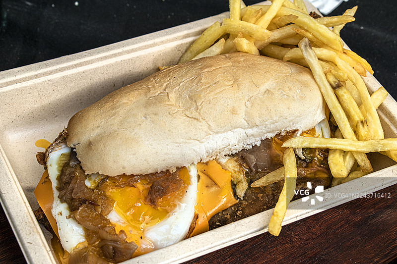 米兰三明治，配煎蛋、切达奶酪、蔬菜和炸薯条。阿根廷传统美食。图片素材