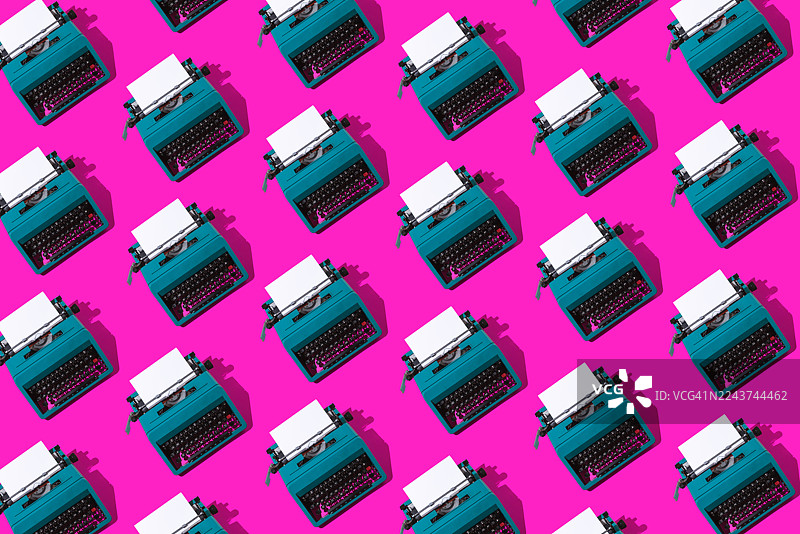 粉色背景上，绿色复古打字机的图案，配有空白页面。编剧、作家、写作、新闻、文学与文化。图片素材