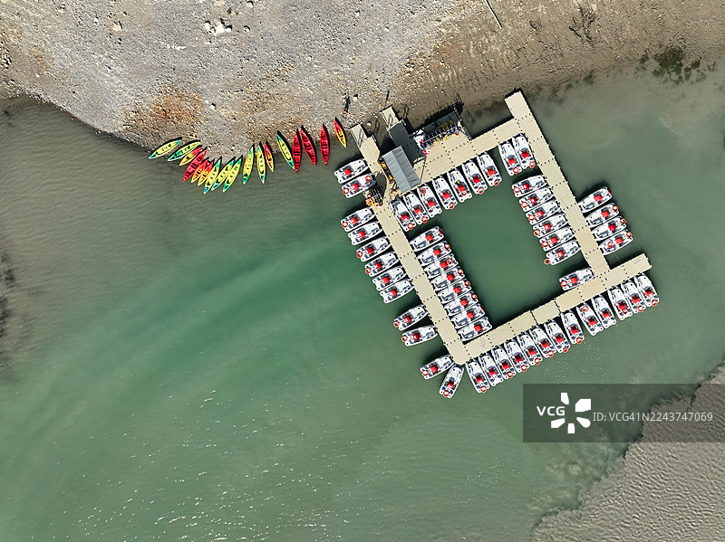 从上方看到的脚踏船和皮划艇停靠在法国瓦尔省韦尔东地区自然公园圣十字湖（Sainte Croix Lake）边供出租。图片素材