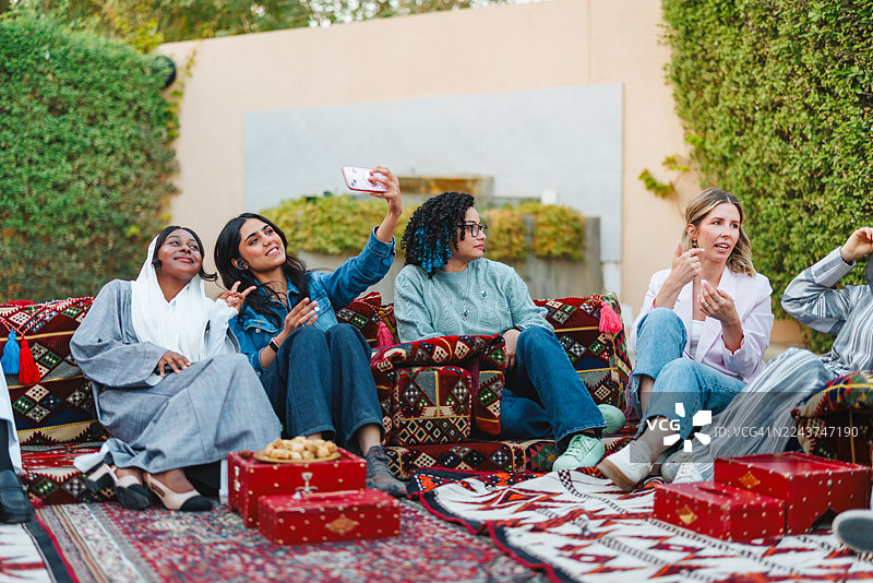 不同肤色的女性们在传统阿拉伯جلس区开心地自拍图片素材