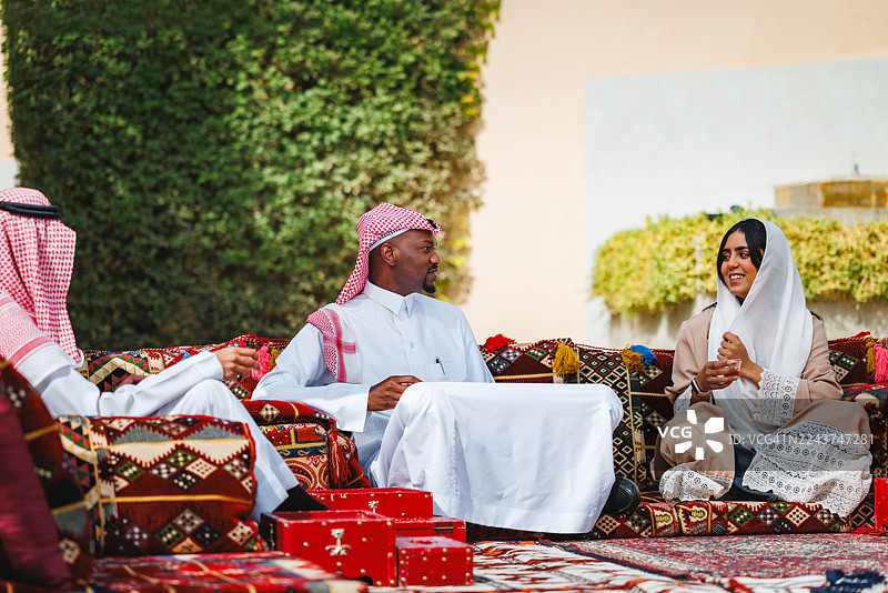 中东男女在户外喝咖啡，愉快地交谈图片素材