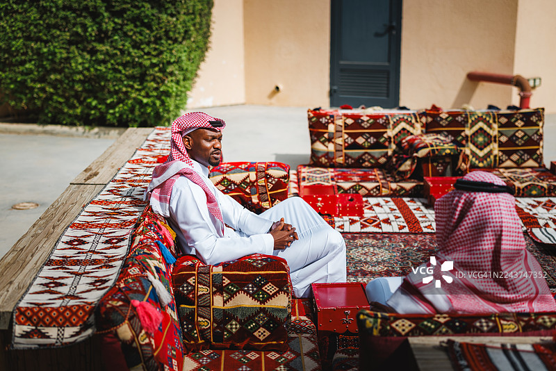 中东男子在传统的阿拉伯جلس户外环境中放松和社交图片素材