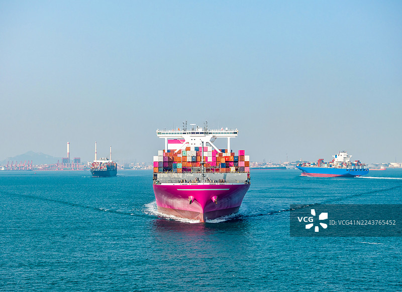 中国山东省青岛市海上航行的三艘集装箱货船图片素材