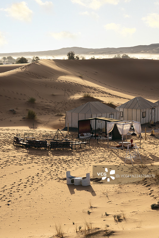 撒哈拉沙漠沙丘中的露营地，设有帐篷和休息区图片素材