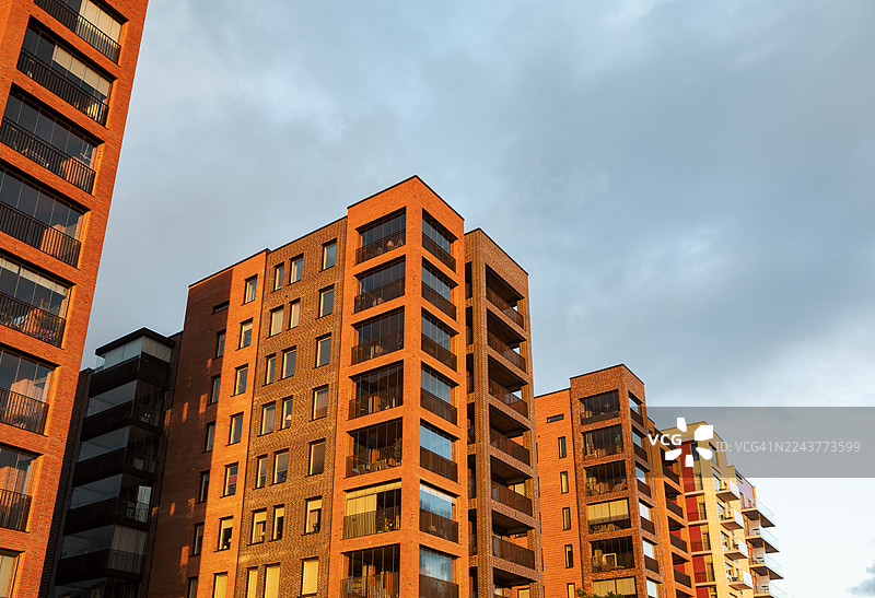 傍晚的灯光下，城市里一座现代化公寓楼的细节。图片素材