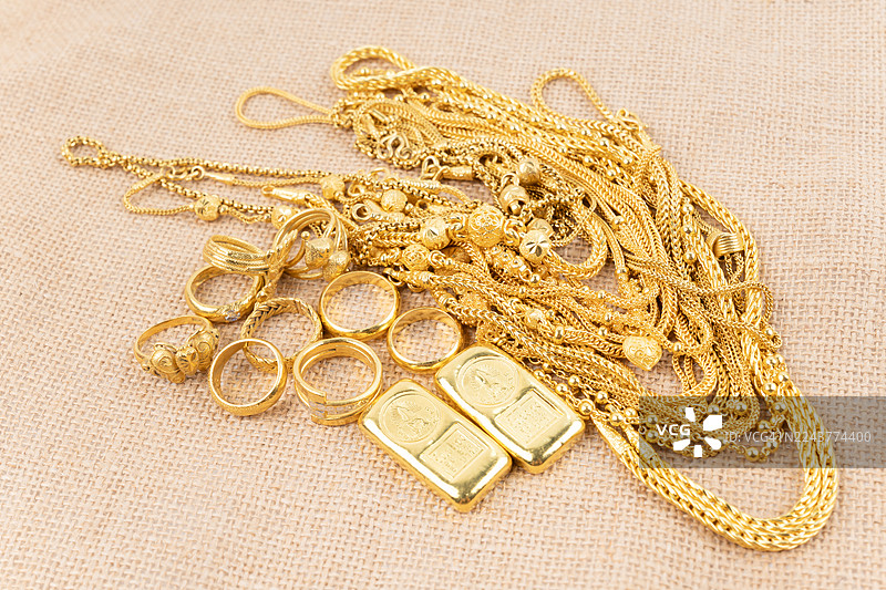 麻布背景上的金项链和金戒指图片素材