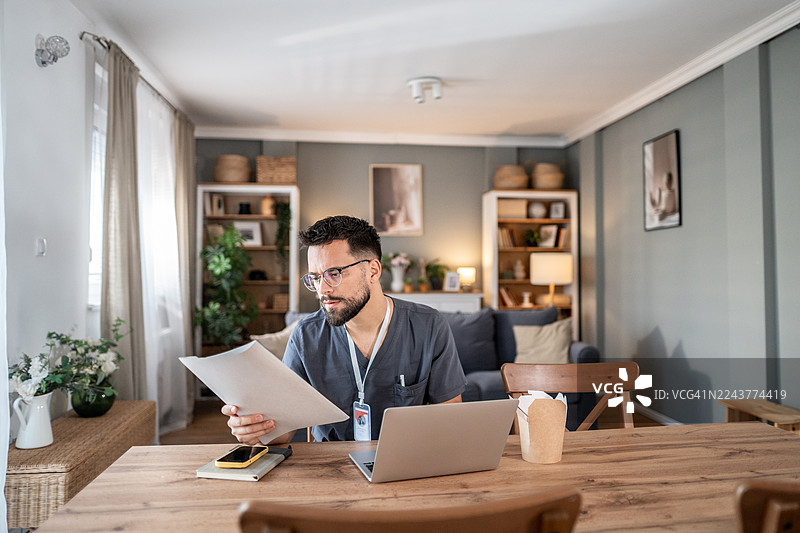 男医生在家远程审阅文件图片素材