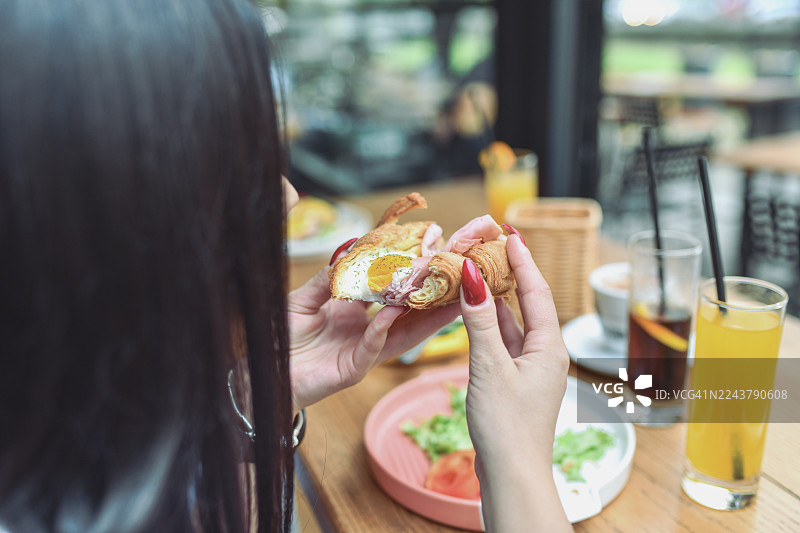 朋友们在现代酒廊酒吧享用早餐三明治，旁边还有饮品和新鲜蔬菜图片素材