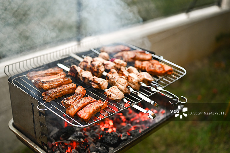 在炭火上烤制串肉和排骨图片素材