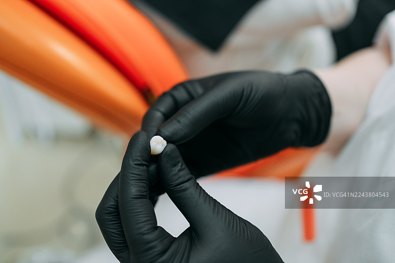 牙医手持牙冠用于牙齿修复图片素材