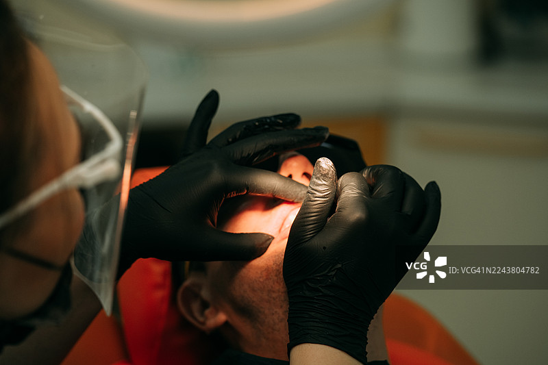 牙医在牙科诊所为患者进行牙科检查图片素材
