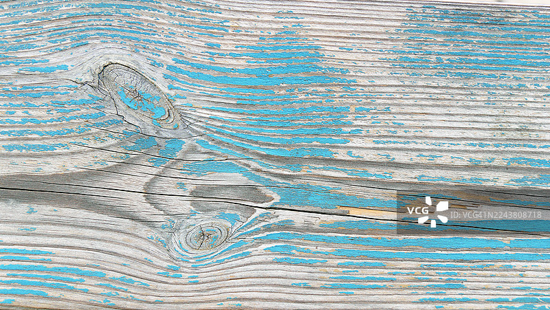 木板上风化的蓝白漆。粗糙的纹理。法国上萨瓦省埃维昂莱班。阳光。自然色彩。图片素材