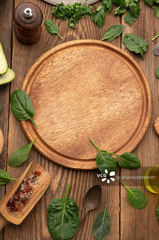 木盘上放着新鲜的菠菜叶和烹饪食材图片素材