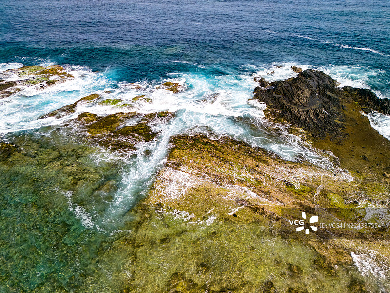 无人机航拍,已获准许。下方是白滨坂户海岸,远处海面上漂浮着龙宫岛。龙宫岛上的白岛神社的红色鸟居清晰可见。图片素材