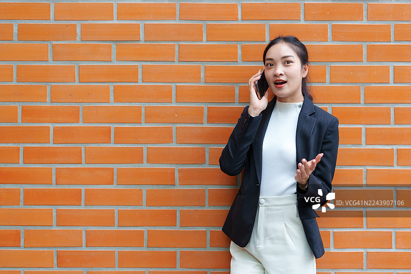 一位女商人在接电话时感到惊讶图片素材