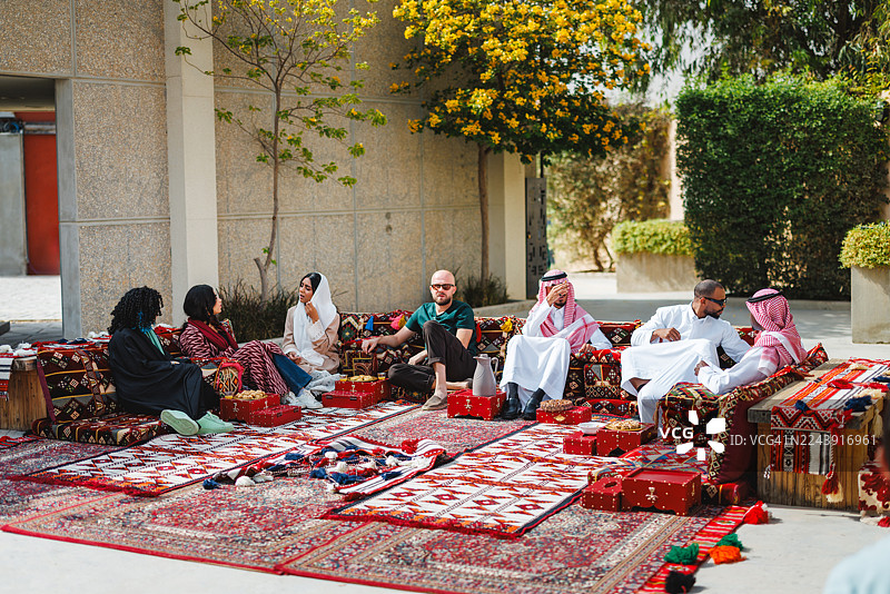 一群中东成年人在户外的马吉利斯（جلس室）里交谈图片素材