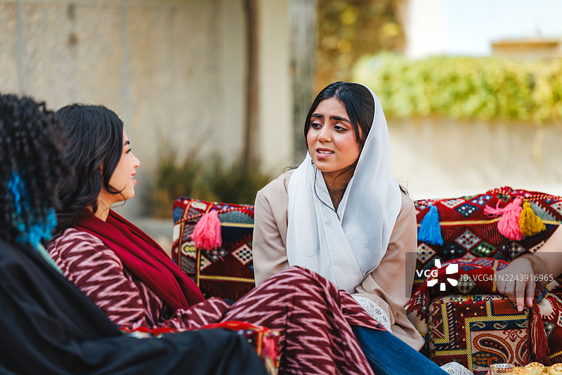 中东女性在户外麦加利斯环境中进行友好交谈图片素材