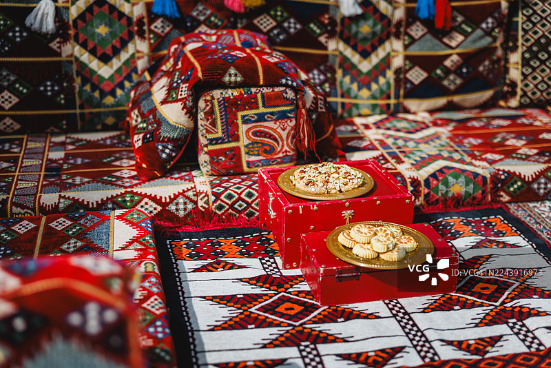 色彩鲜艳的地毯和装饰性靠垫的传统中东جلس区，位于户外图片素材