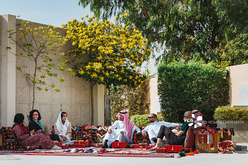 中东成年人在装饰传统的户外麦吉利斯（Majlis）中舒适地社交图片素材