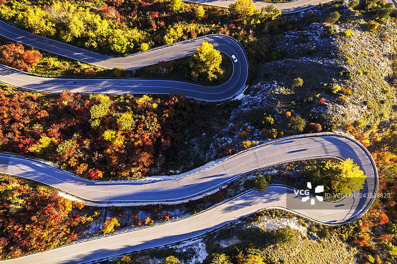 秋季，汽车在山路上行驶，蜿蜒曲折。图片素材