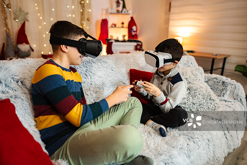 兄弟俩在圣诞节玩虚拟现实电子游戏图片素材