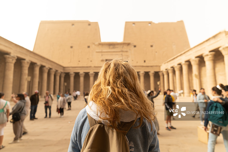 一位女性游客在埃及埃德富的荷鲁斯神庙中行走，埃斯纳和阿斯旺在埃及图片素材