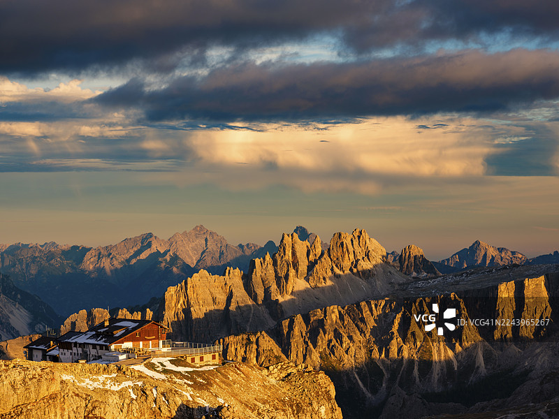 阿尔卑斯山日落,拉加佐伊山间小屋和崎岖的白云岩山峰在傍晚的阳光下,意大利威尼托大区贝卢诺省多洛米蒂阿尔卑斯山区图片素材