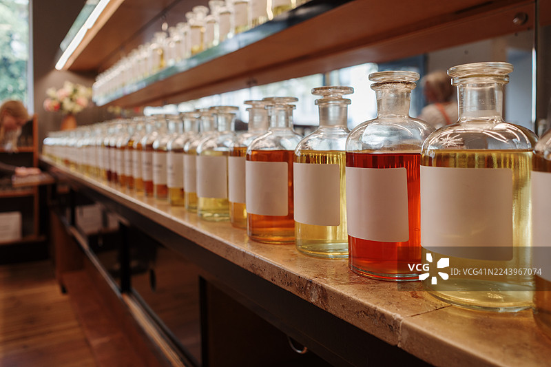 一家奢华香水店里，一排排色彩缤纷的香水瓶，标签空白。图片素材