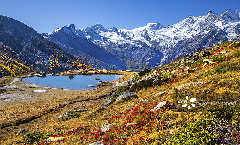 秋季的克鲁兹博登湖,背景是海拔 4027 米的阿拉林峰、海拔 4206 米的阿尔普贝尔峰和海拔 4545 米的米沙贝尔山群,位于瑞士瓦莱州萨斯塔尔萨斯格伦德。图片素材