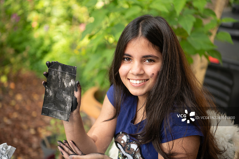女孩展示她用果汁盒制作的印刷板图片素材