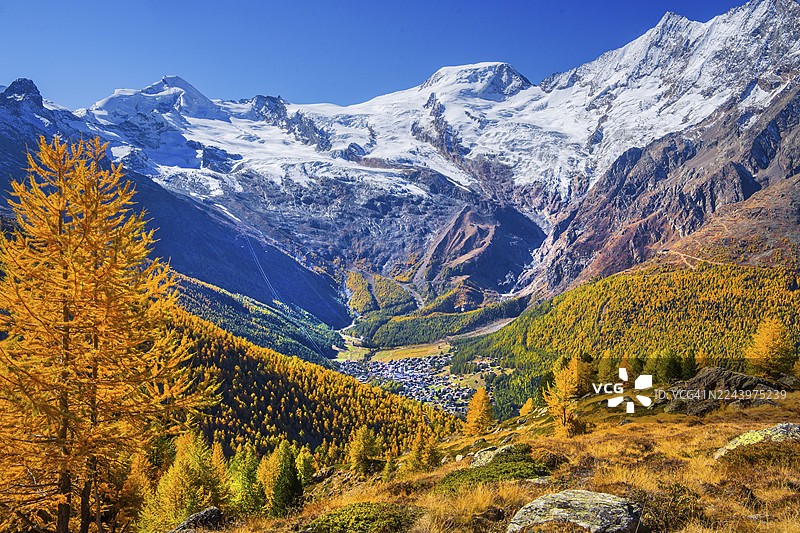 秋季,从克鲁兹博登山(Kreuzboden)眺望萨斯费(Saas-Fee),远景为海拔4027米的阿林峰(Alalin)和海拔4206米的阿尔普贝尔峰(Alphubel),位于瑞士瓦莱州萨斯格伦德(Saas-Grund)的萨斯河谷(Saasertal)。图片素材