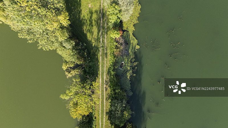洪水泛滥的田野的鸟瞰图，有茂盛的植被和狭窄的小径图片素材