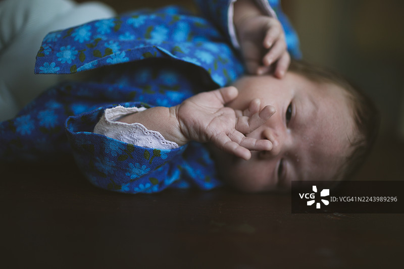 可爱的女新生儿躺在黑色表面上图片素材