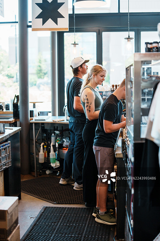 咖啡店收银台前的团队合作图片素材