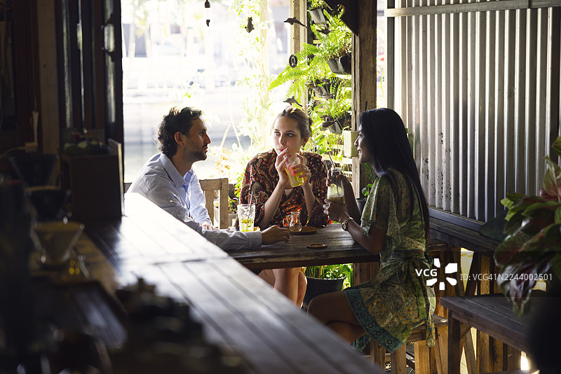 泰国曼谷咖啡馆里，年轻的游客朋友们正在饮品畅聊图片素材