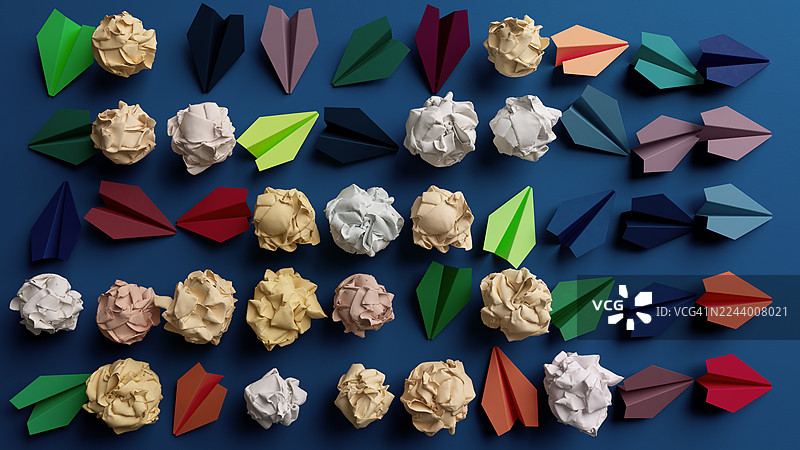 蓝色桌面上的彩色折纸形状和揉皱的纸团，创意俯视平铺图片素材