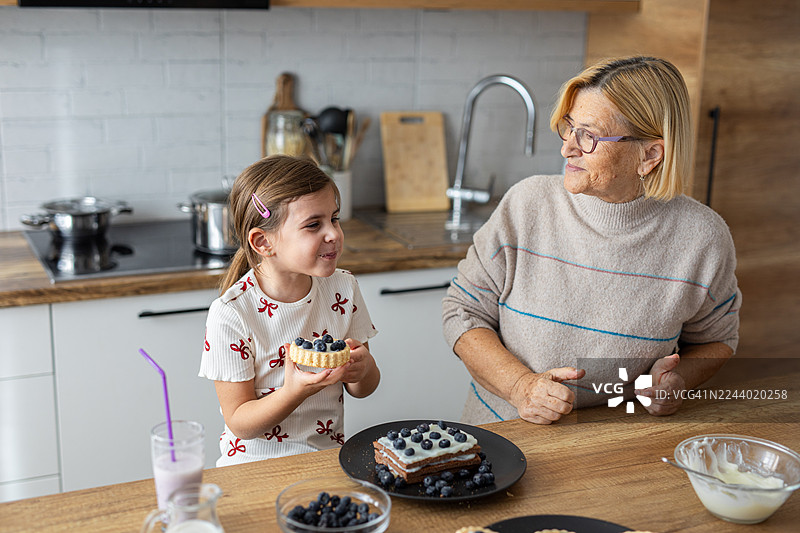祖母和孩子在家享受自制蓝莓甜点的快乐家庭时光图片素材