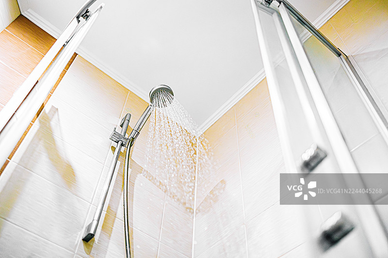 浴室里的淋浴喷头喷出水以保持清洁图片素材