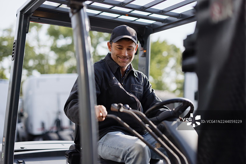 仓库工人驾驶叉车并微笑图片素材