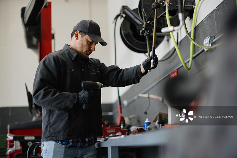 一名技师在车库里修理汽车零件图片素材