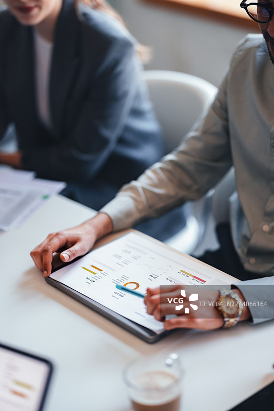 专业团队在现代办公室的商务会议中，使用平板电脑分析图表图片素材