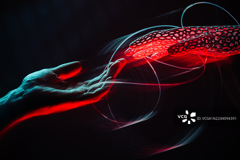 一只人类的手伸出，触碰着一只发着红光的、未来科技感的、生物工程3D打印的手，周围是黑暗背景中旋转的光条。图片素材
