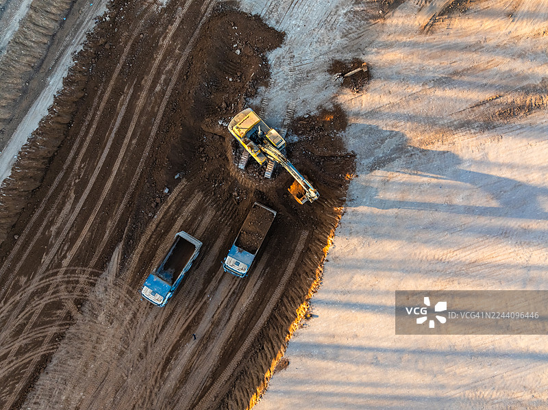 卡车装载挖掘机的土壤。鸟瞰图图片素材