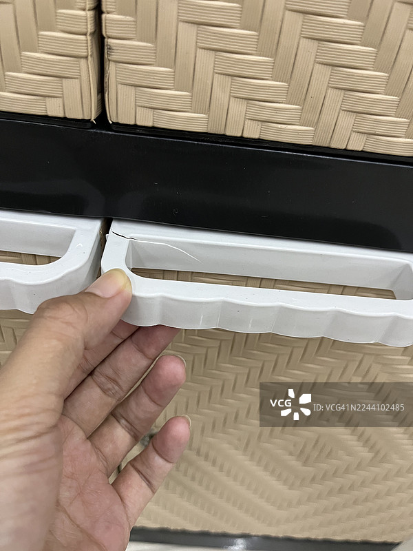 手握破碎的塑料橱柜把手图片素材