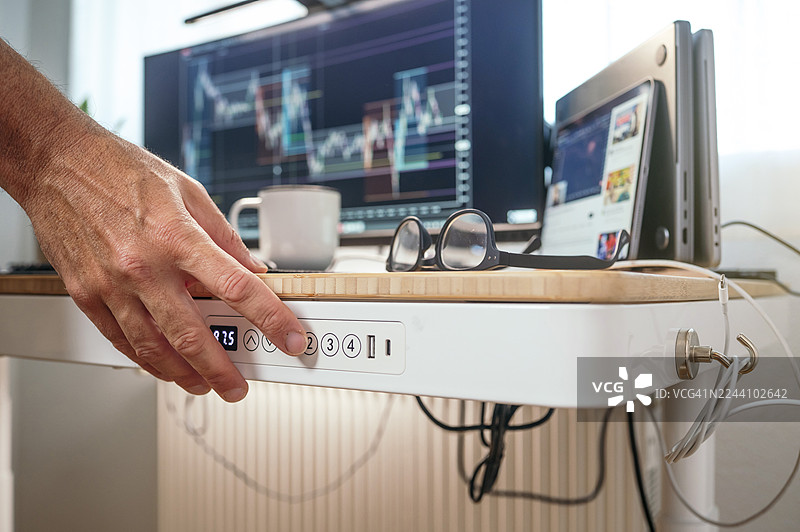 手正在调节升降桌的高度图片素材