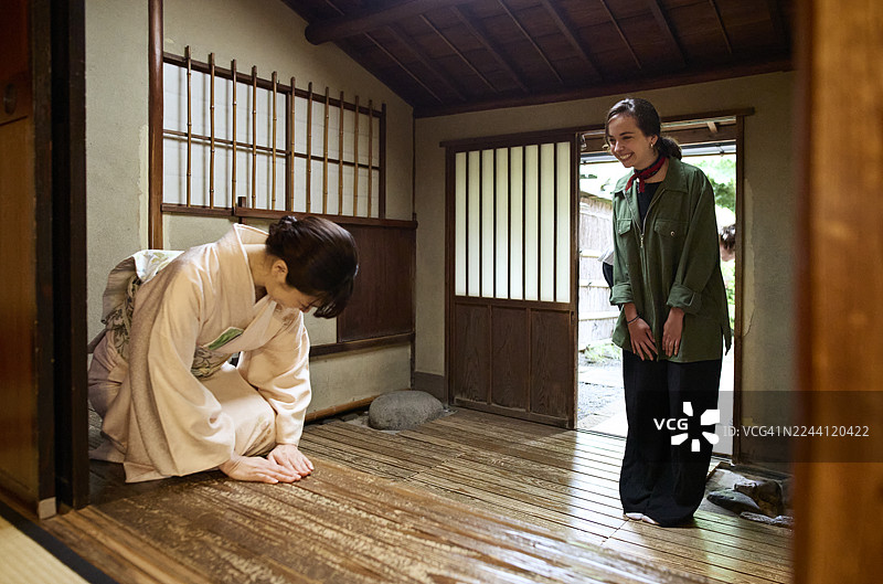 微笑的年轻女子向日本女主人打招呼图片素材